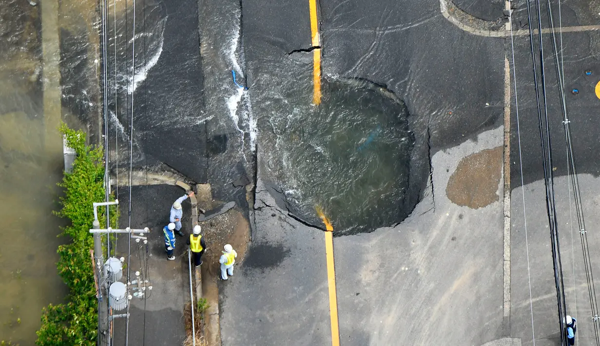Air keluar dari retakan dan membanjiri jalan menyusul gempa bumi di Takatsuki, Osaka, Jepang, Senin (18/6). Gempa berkekuatan 6,1 SR menghantam Osaka pada Senin pagi. (Yohei/Nishimura/Kyodo News via AP)