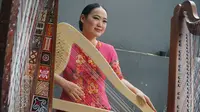 Musisi asal Bandung yang juga pemain harpa Frasisca Agustin menampilkan harpa bermotif Batik Kawung yang merupakan salah satu motif batik Jawa tertua. (Liputan6.com/Huyogo Simbolon)
