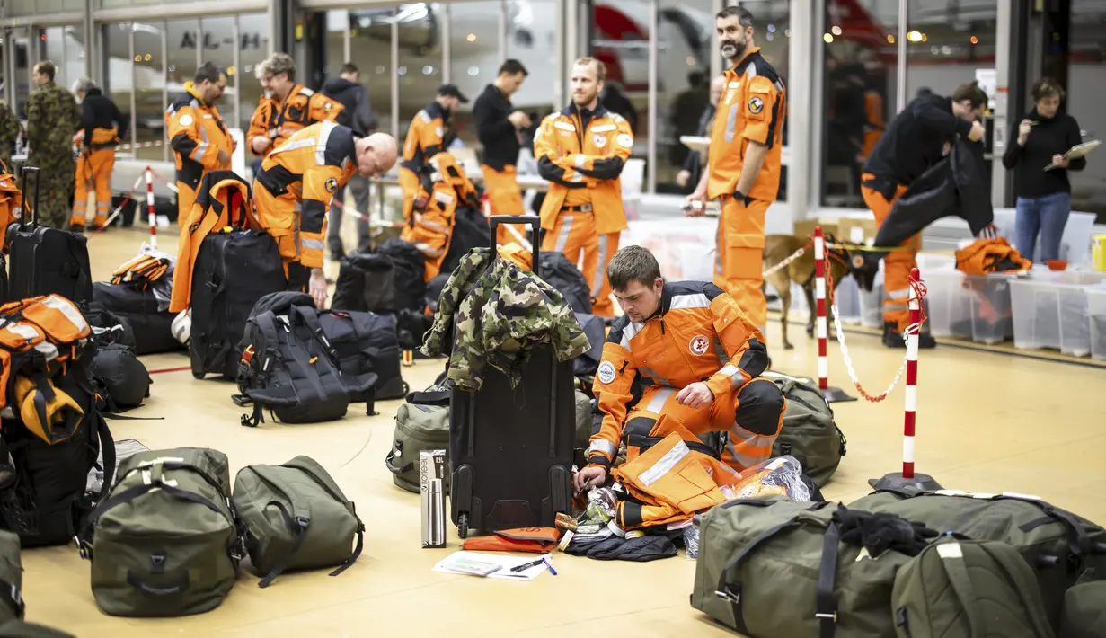Pakar dan penyelamat Swiss dengan anjing pemandu bersiap untuk terbang ke Turki yang dilanda gempa, di Bandara Zurich, Swiss, Senin (6/2/2023). Gempa kuat telah merobohkan beberapa bangunan di tenggara Turki dan Suriah dan dikhawatirkan banyak korban jiwa. (Michael Buholzer/Keystone via AP)