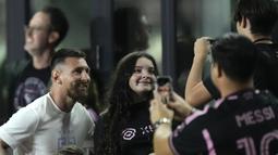 Pemain Inter Miami, Lionel Messi (kiri), berpose bersama penggemar setelah menyaksikan timnya melawan Charlotte FC pada lanjutan kompetisi Major League Soccer 2023/2024 yang berlangsung di DRV PNK Stadium, Kamis (19/10/2023). (AP Photo/Rebecca Blackwell)