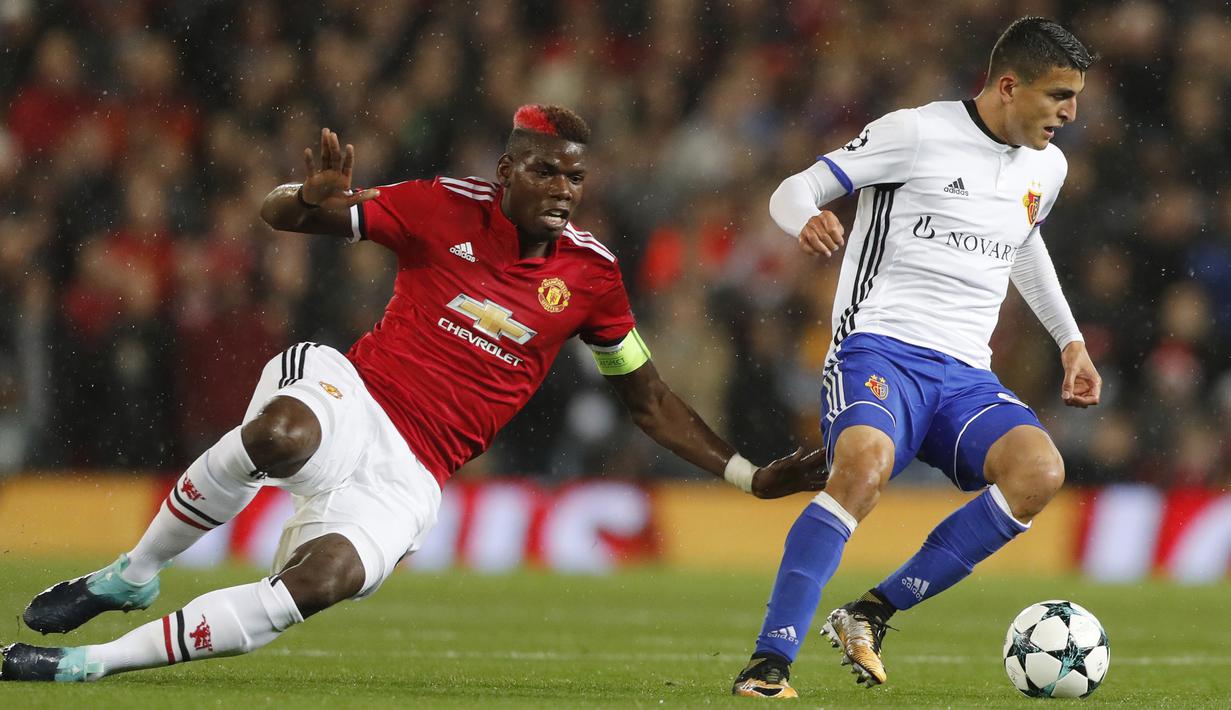 Pemain Basel, Mohamed Elyounoussi (kanan) mengecoh pemain Manchester United, Paul Pogba pada laga  grup A Liga Champions di Old Trafford, Manchester, (12/9/2017). MU menang 3-0. (AP/Frank Augstein)