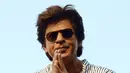 Aktor Bollywood, Shahrukh Khan memberi salam kepada para fans yang berkumpul dari balkon rumahnya di Mumbai, Kamis (2/11). Bagi warga India, datang ke kediaman SRK pada ulang tahunnya sudah menjadi tradisi penggemar. (Sujit Jaiswal/AFP Photo)