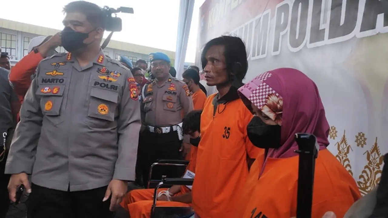 Pasangan suami istri tersangka penganiayaan anak disabilitas saat dihadirkan di Polda Riau.