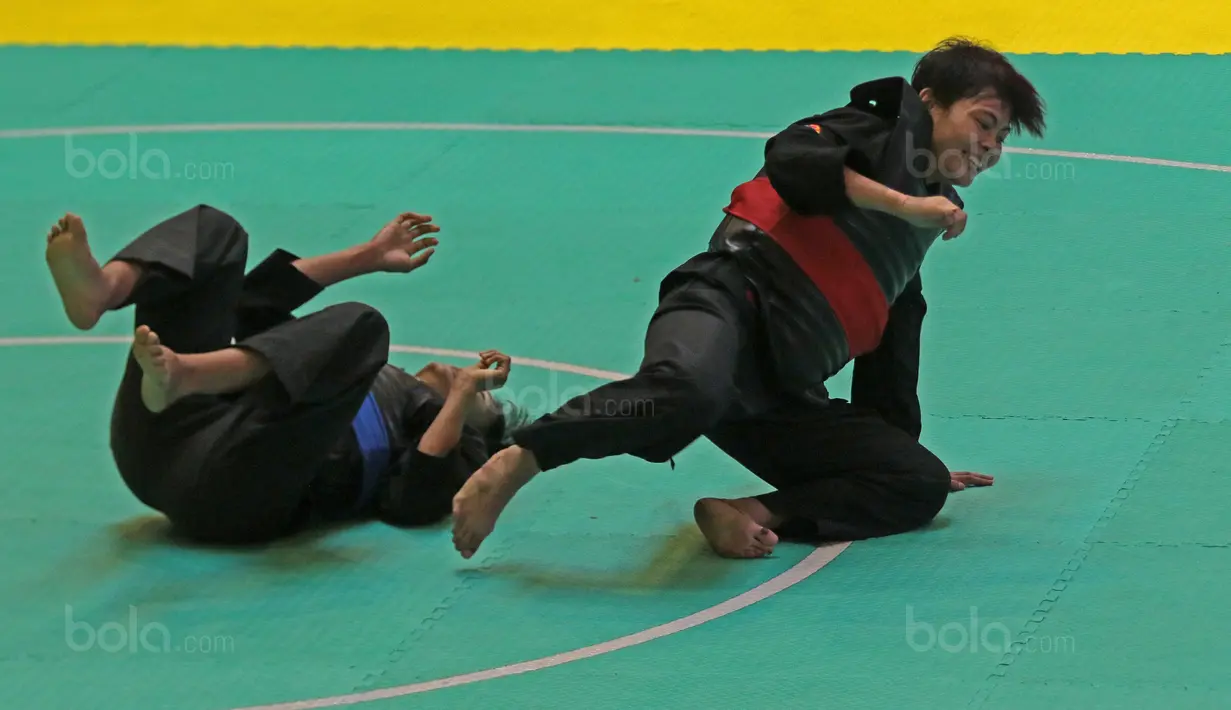 Pesilat Indonesia, Octaviani Nirmalasari (kanan) tertawa usai membanting pesilat Laos, Olahthai Sounthavong pada semifinal Test Event Pencak Silat 2018 di Padepokan Silat TMII, Jakarta, (12/2/2018). Oktaviani menang 5-0. (Bola.com/Nick Hanoatubun)