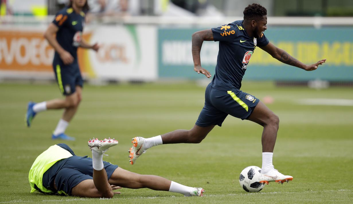 Ekspresi pemain Brasil, Fred (kanan) yang kesakitan setelah di jegal Casemiro pada sesi latihan di lapangan latihan Tottenham Hotspur football club, Inggris, (7/6/2018). Fred mengalami masalah di engkel kaki. (AP/Matt Dunham)