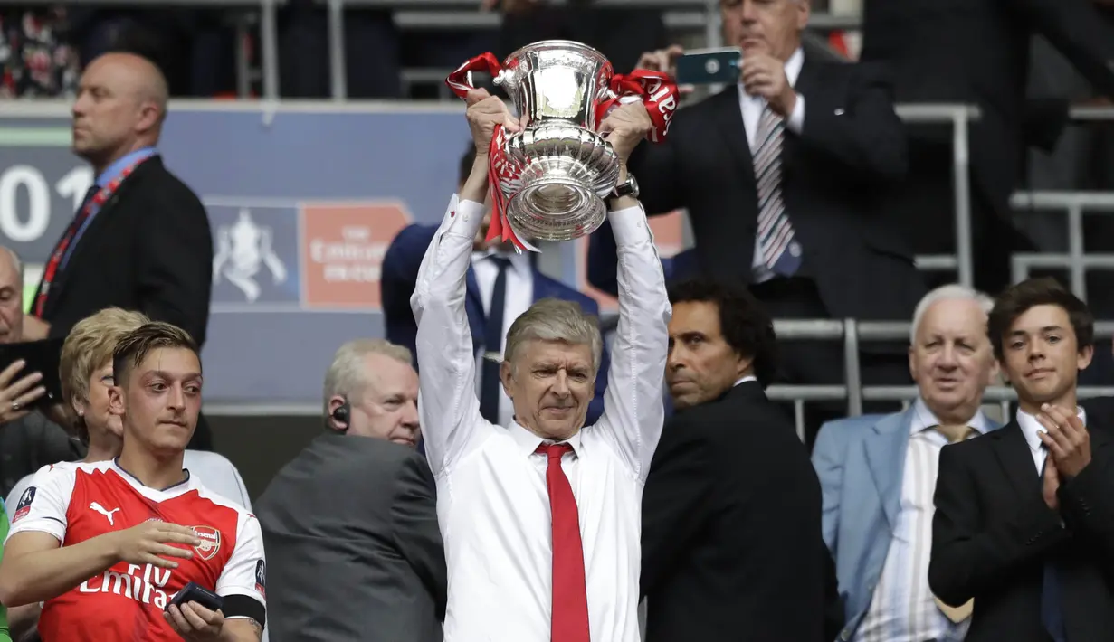 Pelatih Arsenal, Arsene Wenger, mengangkat trofi usai menjuarai final Piala FA melawan Chelsea di Stadion Wembley, Sabtu (27/5/2017). Arsenal menang 2-1. (AP/Matt Dunham)