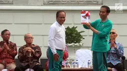 Presiden Jokowi memberi buku kepada Menristek Dikti, Muhammad Nasir saat Peluncuran Program Penguatan Pendidikan Pancasila di Istana Bogor, Jawa Barat, Sabtu (12/8). (Liputan6.com/Angga Yuniar)