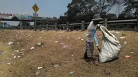 Seorang pemulung mencari botol dan gelas plastik di Tol Jagorawi. (Liputan6.com/Bima Firmansyah)