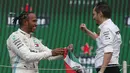 Pembalap Mercedes dari Inggris, Lewis Hamilton berselebrasi dengan anggota tim Marcelo Martinelli setelah berhasil menjuarai balapan GP Meksiko di Autodromo Hermanos Rodriguez, Mexico City (28/10/2019). (AP Photo/Rebecca Blackwell)