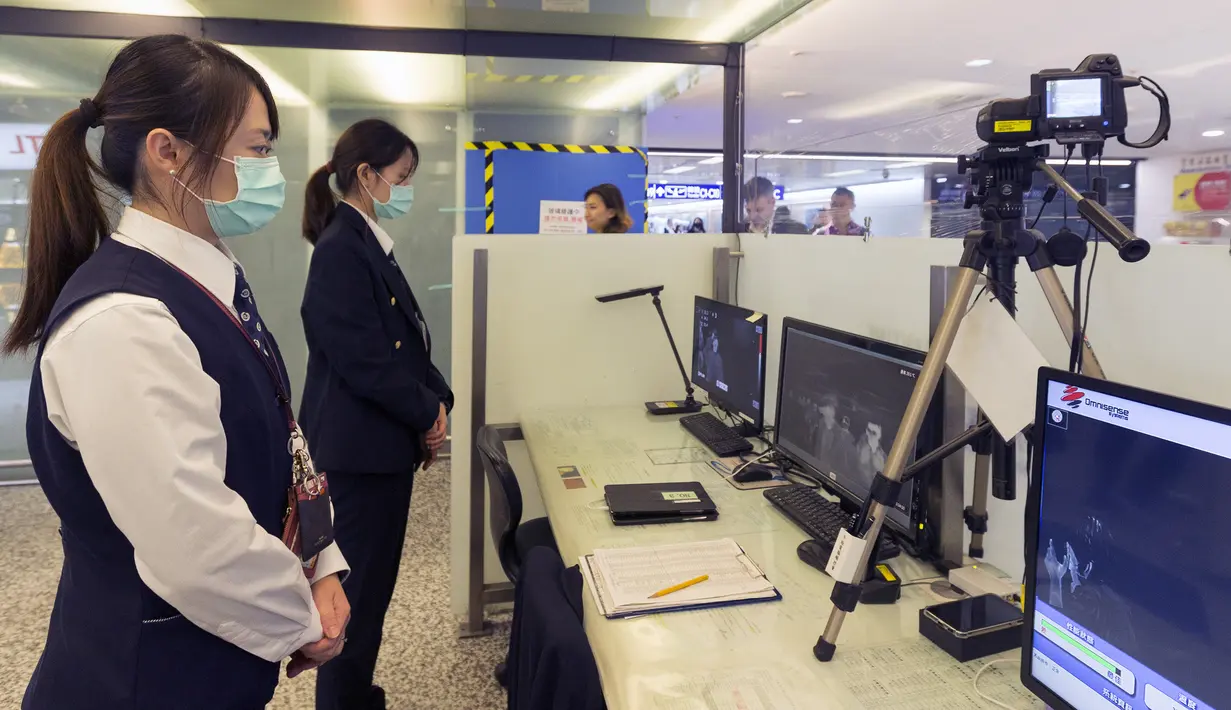 Personel Center for Disease Control (CDC) Taiwan memindai suhu tubuh penumpang yang tiba dari penerbangan Wuhan China di Bandara Taoyuan International (13/1/2020). Jumlah kematian yang diakibatkan oleh wabah virus corona hampir dua kali lipat hanya dalam 24 jam. (AFP Photo/Chen Chi-chuan)