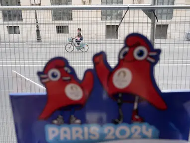 Seorang berkendara dengan sepeda di luar perimeter keamanan yang disiapkan untuk Olimpiade di Paris, Kamis (18/7/2024). (AP Photo/David Goldman)