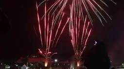 Warga menyaksikan pesta kembang api saat perayaan malam puncak Tahun Baru 2023 di Danau Archipelago, Taman Mini Indonesia Indah (TMII), Jakarta, Minggu (1/1/2023). Danau Archipelago TMII menjadi pusat pesta kembang api di malam tahun baru 2023. (Liputan6.com/Herman Zakharia)