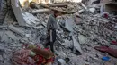 Seorang pria berjalan di tengah reruntuhan rumah yang hancur akibat serangan Israel di Khan Younis, Jalur Gaza selatan, pada Rabu 29 Oktober 2025. Hingga Rabu (29/10/2025), dikabarkan sedikitnya 91 orang tewas akibat serangan itu. (BASHAR TALEB/AFP)