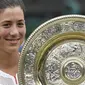 Garbine Muguruza berpose dengan gelar Wimbledon 2017. Petenis asal Spanyol itu mengalahkan Venus Williams 7-5, 6-0 di final, Sabtu (15/7/2017). (AFP/Glyn Kirk)