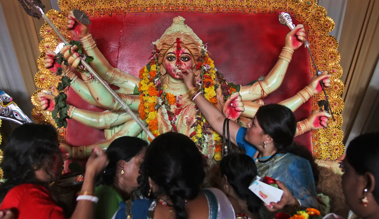 Perempuan Hindu menyuapi makanan untuk dewi Durga pada hari terakhir festival Durga Puja di Hyderabad, India (11/10). Festival Durga Puja merupakan festival tahunan terbesar di Asia Selatan untuk memuja dewi Durga di agama Hindu. (AP Photo/ Mahesh Kumar)