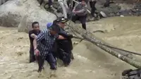 Orang nomor satu di Kabupaten Labura tersebut tergelincir ke dalam sungai berarus deras saat melewati jembatan darurat yang terbuat dari bambu. Dalam video berdurasi 1 menit 19 detik yang beredar, Kharuddin tampak hendak menyeberangi titi darurat.