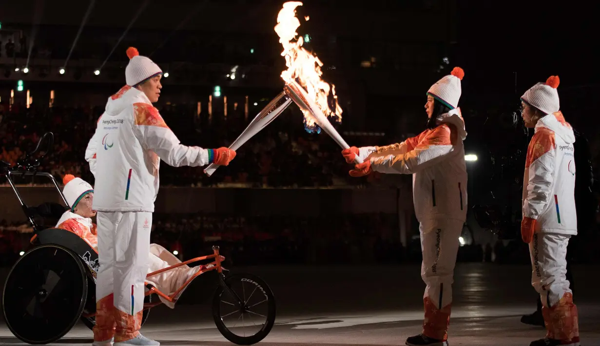 Seo Soon-Seok dan Kim Eun-jung dari Korea Selatan bersiap menyalakan Paralympic Cauldron dalam Upacara Pembukaan Paralympics 2018 di Stadion Olimpiade di Pyeongchang, Korea Selatan, (9/3). (Simon Bruty/OIS/IOC via AP)