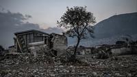 Sebuah pohon jeruk berada di samping bangunan yang rusak di Antakya, provinsi Hatay, wilayah selatan Turki pada tanggal 5 Februari 2024. (Ozan KOSE/AFP)