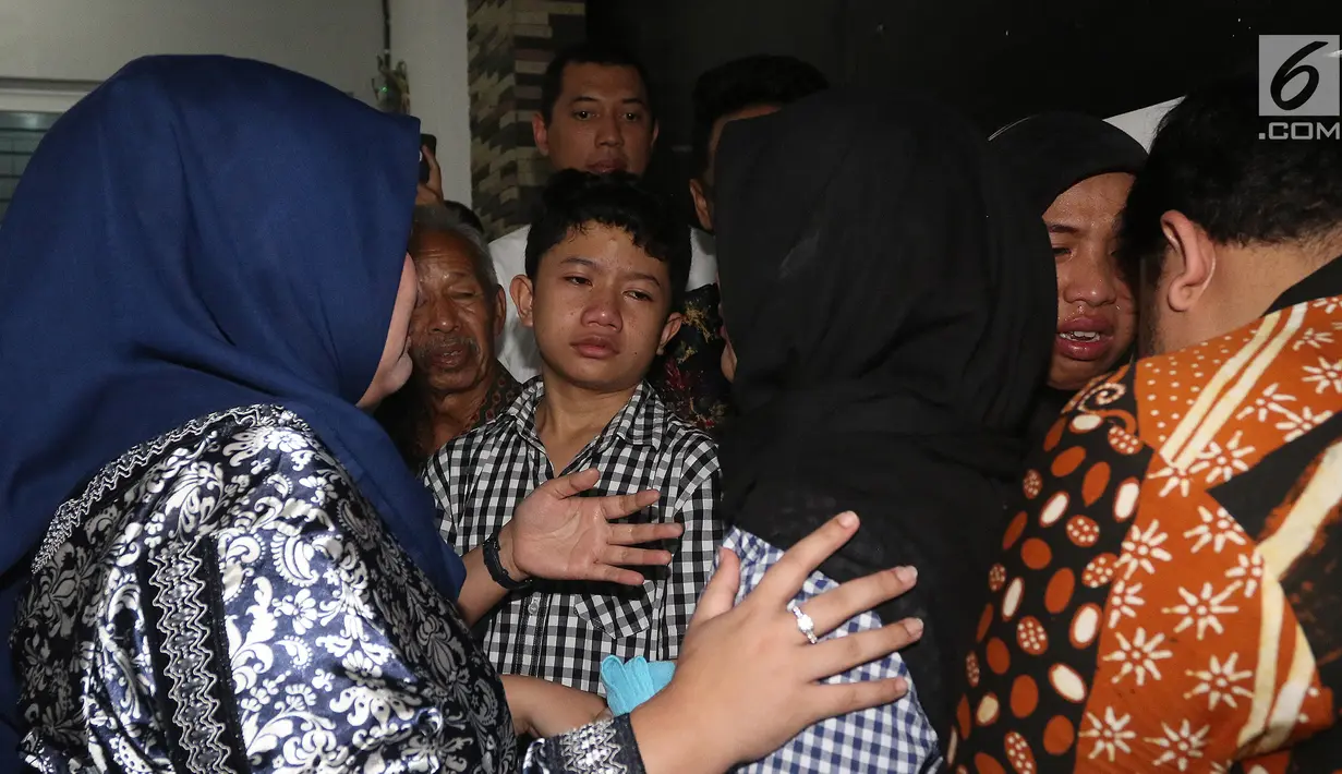 Kesedihan Muhammad Aufa Wikantyasa Nugroho, anak Kepala Pusat Data Informasi dan Humas Badan Nasional Penanggulangan Bencana (BNPB) Sutopo Purwo Nugroho saat peti jenazah sang ayah tiba di rumah duka di Raffles Hils, Depok, Minggu (7/7/2019). (Liputan6.com/Herman Zakharia)