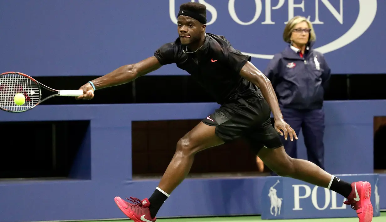 Petenis AS, Frances Tiafoe saat mengembalikan bola pukulan Petenis Swiss, Roger Federer saat bertanding pada turnamen tenis AS Terbuka 2017 di New York (29/8).  Frances Tiafoe merupakan petenis junior terbaik AS berumur 19 tahun. (AP Photo/Julio Cortez)