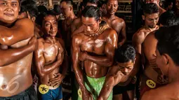 Para Jebor mengoleskan minyak disekujur tubuhnya. Bentuk badan yang berotot itu bukan dihasilkan dari latihan di gim atau pusat latihan kebugaran. (Liputan6.com/Gempur M Surya)