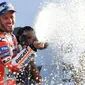 Pembalap Tim Ducati Corse, Andrea Dovizioso menyemprot sampanye saat merayakan kemenangannya di atas podium GP Inggris di Sirkuit Silverstone, Minggu (27/8). Dovizioso mengungguli dua pembalap Yamaha, Maverick Vinales dan Valentino Rossi. (OLI SCARFF/AFP)