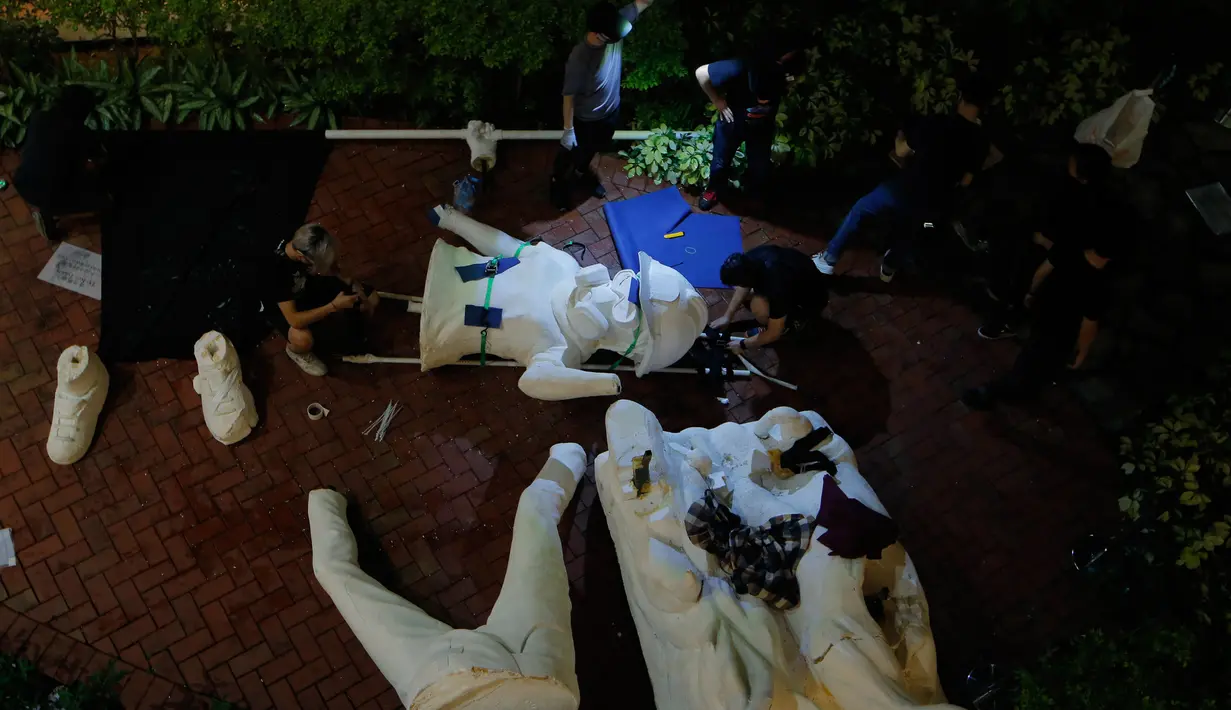 Demonstran antipemerintah bersiap mendirikan patung The Lady Liberty of Hong Kong di puncak pegunungan Lion Rock, Hong Kong, Minggu (13/10/2019). Patung tersebut digambarkan tengah mengenakan topeng gas, helm, dan kacamata pelindung. (AP Photo/Kin Cheung)