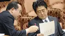 Perdana Menteri Jepang Shinzo Abe (kanan) menerima penjelasan tentang kapal tanker yang meledak di sekitar stasiun dekat pantai Prefektur Hyogo, sekitar 450 kilometer barat Tokyo, (29/5/2014). (AFP PHOTO/JIJI PRESS)