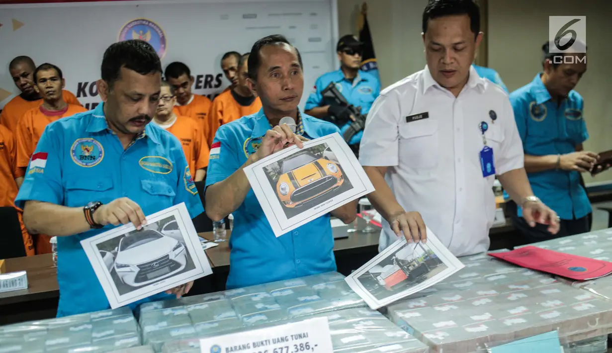 Petugas menunjukkan foto barang bukti saat rilis Kasus Tindak Pidana Pencucian Uang (TPPU) di Gedung BNN, Jakarta, Kamis (25/7/2019). BNN menyita total aset sebesar Rp 60 milliar. Aset tersebut berasal dari hasil ungkap 20 kasus narkotika dari Januari hingga Juli 2019. (Liputan6.com/Faizal Fanani)