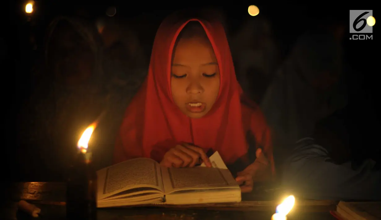 Santri dari Pondok Pesantren  Nurul Hidayah melakukan tadarus alquran dengan penerangan obor di tengah sawah Dusun Tempel, Desa Sempu, Kecamatan Andong, Kabupaten Boyolali, Selasa ( 21/5/2019). Pengajian tersebut untuk menyambut malam Nuzulul Quran pada 17 Ramadan 1440 Hijriah. (Liputan6.com/Gholib)