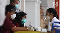 Petugas mendata warga yang mengikuti vaksinasi COVID-19 di Vihara Avalokhitesvara, Mangga Besar, Jakarta, Minggu (29/8/2021). Hal ini dilakukan untuk mencapai herd immunity atau kekebalan komunal di wilayah tersebut. (Liputan6.com/Herman Zakharia)