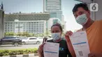 Warga menunjukkan kartu vaksinasi COVID-19 di Gerai Vaksinasi Presisi, Bundaran HI, Menteng, Jakarta, Minggu (20/3/2022). Kegiatan vaksin booster tersebut diinisasi Polsek Menteng bersama tiga pilar menggunakan jenis vaksin Astra Zeneca dengan kuota 100 dosis per hari. (Liputan6.com/Faizal Fanani)
