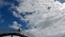 Orang-orang berjalan di sebuah instalasi tangga melingkar "Tiger and Turtle" di Duisburg, Jerman, 30 April 2018. Jika malam hari tiba, sisi kanan dan kirinya akan mengeluarkan cahaya, sehingga menambah keindahan tempat ini. (AP/Martin Meissner)