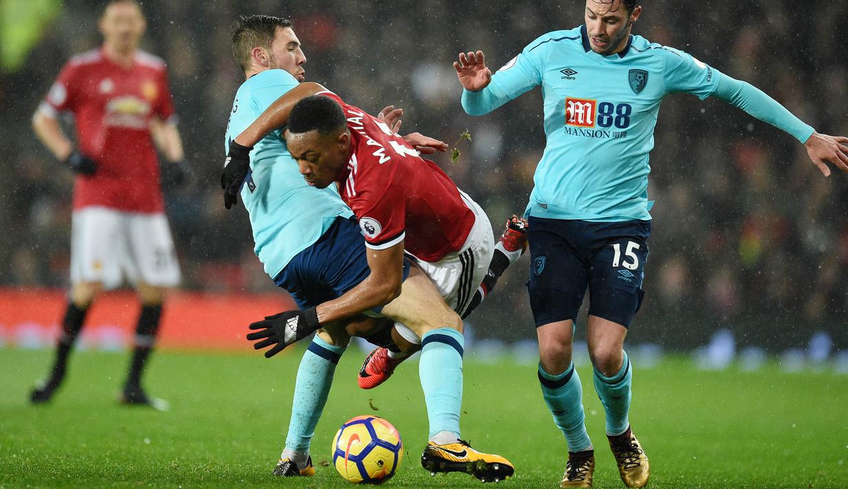 Striker Manchester United, Anthony Martial, terjatuh saat berebut bola dengan gelandang AFC Bournemouth, Brad Smith, pada laga Premier League di Stadion Old Trafford, Rabu(13/12/2017). Manchester United menang 1-0 atas AFC Bournemouth. (AP/Oli Scarff)