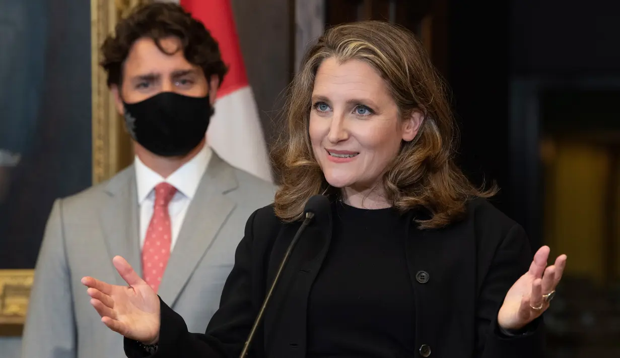 Perdana Menteri Kanada, Justin Trudeau menyimak saat Wakil PM dan Menteri Keuangan Chrystia Freeland saat konferensi pers di Parliament Hill, Ottawa, Selasa (18/8/2020). PM Trudeau mengangkat Chrystia Freeland sebagai menteri keuangan perempuan pertama Kanada. (Adrian Wyld/The Canadian Press via AP)