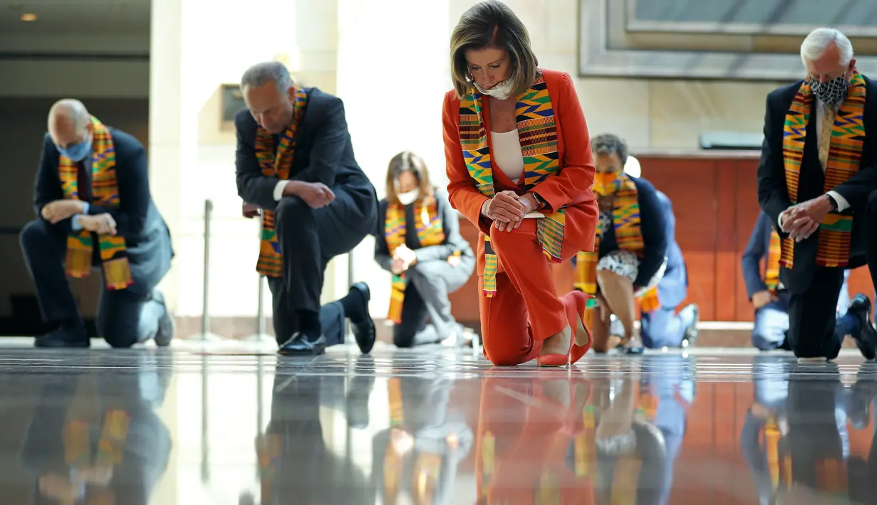 Ketua DPR Nancy Pelosi bersama anggota Kongres AS dari Fraksi Demokrat berlutut dan mengheningkan cipta di Gedung Kongres AS, Senin (8/5/2020). Mereka berlutut untuk memberikan penghormatan terhadap mendiang George Floyd dan korban kebrutalan polisi lainnya. (Chip Somodevilla/Getty Images/AFP)