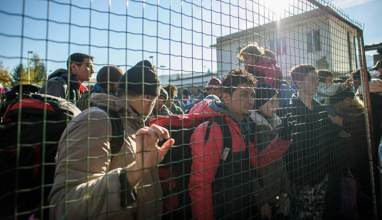 Ribuan imigran bersama bayinya berdesakan di Sentilj, Slovenia untuk memasuki Austria, Selasa (3/11). Slovenia mengatakan kewalahan menghadapi arus ribuan migran yang melintasi wilayah negara itu untuk menuju Eropa barat. (AFP PHOTO/RENE GOMOLJ)