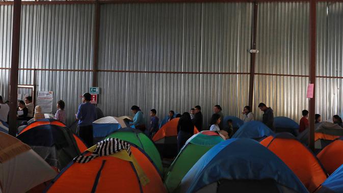 Imigran mengantre makanan di dalam tempat penampungan di Tijuana, Meksiko 6 April 2019. Rombongan migran Amerika Tengah mencapai kota perbatasan antara Meksiko dan AS tersebut  untuk mencari suaka akibat kekerasan, pembunuhan dan kemiskinan yang mengancam