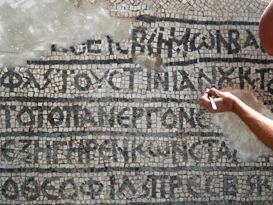 Arkeolog meneliti lantai mosaik berusia 1.500 tahun di Museum Rockefeller, Yerusalem, Rabu (23/8). Prasasti bertuliskan aksara dan bahasa Yunani kuno ditemukan selama pengerjaan pemasangan kabel komunikasi di Kota Tua Yerusalem. (AHMAD GHARABLI/AFP)