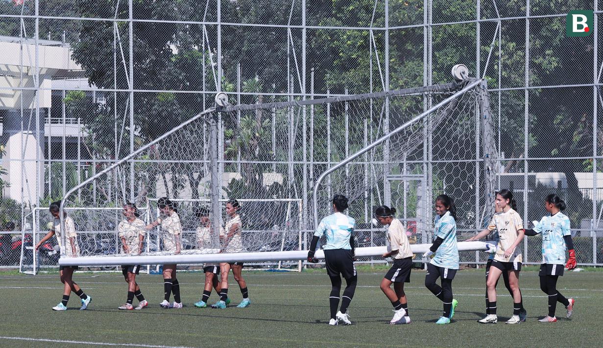Sejumlah pemain Timnas Indonesia Putri memindahkan gawang setelah berlatih di Lapangan ABC, Senayan, Jakarta, Rabu (26/06/2024). (Bola.com/M Iqbal Ichsan)