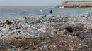 Seorang pria memancing dengan tumpukan sampah di belakangnya yang menutupi pantai Zouq Mosbeh di utara Beirut, Lebanon, 22 Januari 2018. Hampir segala limbah termasuk plastik hingga pembalut wanita menumpuk di pantai itu. (AP/Hussein Malla)