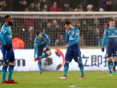 Pemain Arsenal, Henrikh Mkhitaryan (tengah) tertunduk lesu setelah Swansea City mencetak gol ketiga dalam laga pekan ke-25 Premier League 2017-2018 di Liberty Stadium, Selasa (30/1). Arsenal dipaksa menyerah Swansea City 1-3. (Nick Potts/PA via AP)