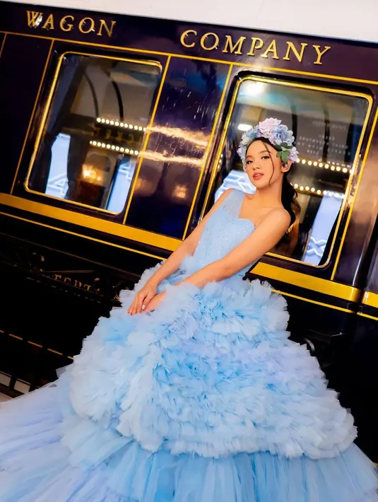 One shoulder ball gown yang outstanding dengan ruffles yang ramai ini instan membuat Lyodra tampak seperti putri raja di kehidupan nyata. Belum lagi, head piece bunga bernuansa biru yang disesuaikan dengan warna gaunnya, menambah kesan manis pada penampilannya secara keseluruhan. Foto: Instagram.