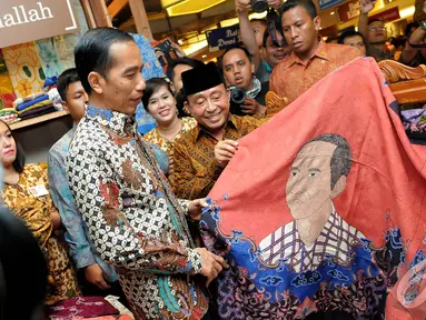 Presiden terpilih Joko Widodo melihat batik bercorak dirinya, Pasaraya Blok M, Jakarta, Kamis (2/10/2014) (Liputan6.com/Herman Zakharia)