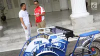 Gubernur DKI Anies Baswedan (kanan) bercengkerama dengan anggota DPR RI Hanafi Rais di Balai Kota DKI Jakarta, Minggu (11/3). Hanafi memberikan prototype becak listrik kepada Anies. (Liputan6.com/Immanuel Antonius)