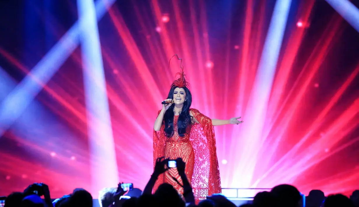 Panggung spektakuler didukung tata cahaya lampu berwarna-warni membuat acara itu terkesan mewah. Krisdayanti tampil dengan gaun merah yang tipis hingga terlihat lekuk tubuhnya. (Adrian Putra/Bintang.com)
