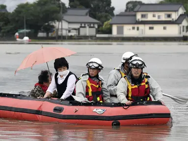 Warga dievakuasi menggunakan perahu karet saat banjir merendam daerah Asakura di prefektur Fukuoka, Kamis (6/7). Hujan lebat yang disebabkan angin topan di selatan Jepang telah memaksa evakuasi hampir 400.000 orang. (Sadayuki Goto/Kyodo News via AP)