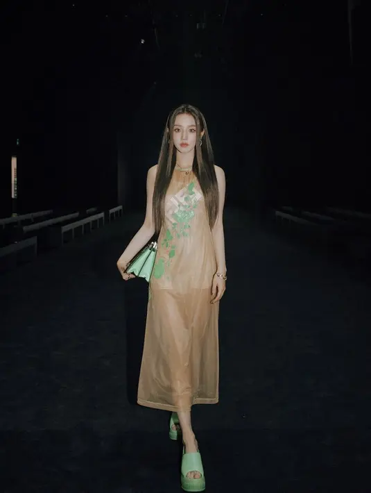 Yuqi (G)-IDLE juga hadir di fashion show Fendi. Ia mengenakan dress panjang cokelat transparan dengan membawa tas hijau. @Fendi