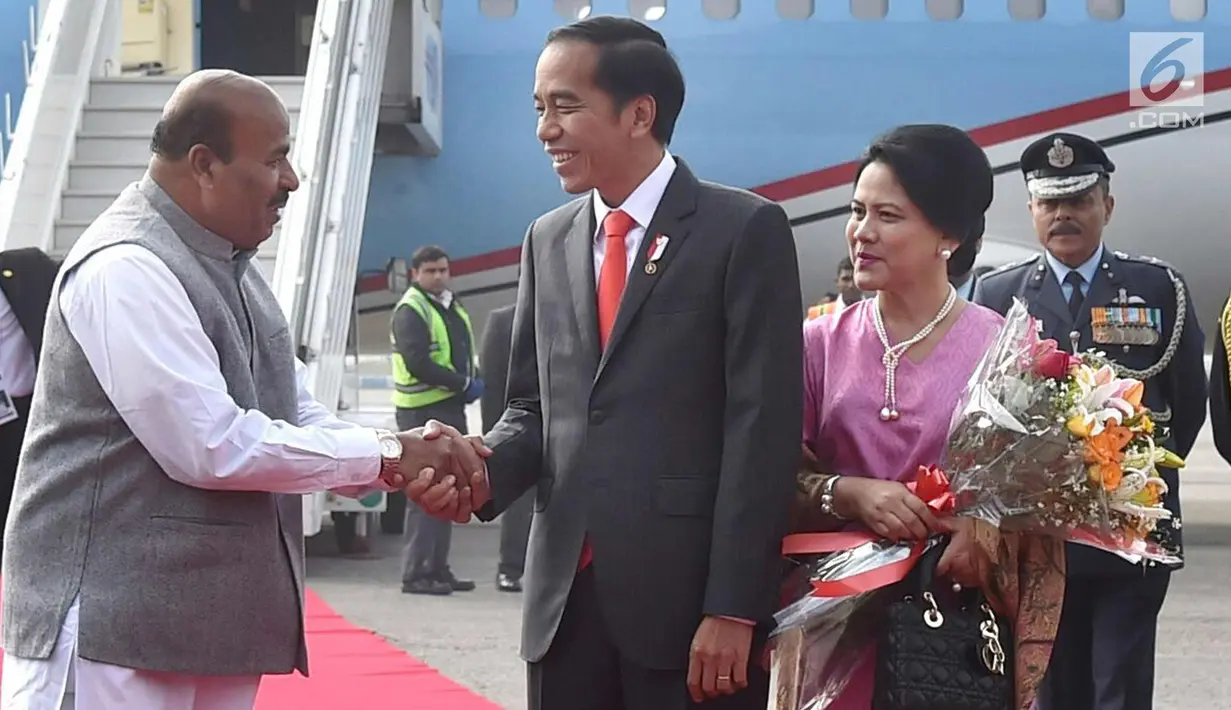 Presiden Joko Widodo bersalaman dengan Kepala Protokol Negara India, Sanjay Verma saat tiba di Pangkalan Udara Palam, New Delhi (25/1). Saat tiba Jokowi dan Ibu Iriana menerima karangan bunga. (Liputan6.com/Pool/Biro Pers Setpres)