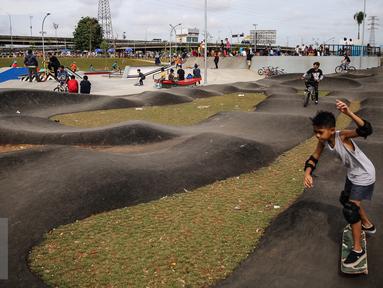 Seorang anak remaja tengah bermain skateboard di jalan aspal Taman Kalijodo, Jakarta, Minggu (15/01). Kalijodo yang dulu tempat menjajakan kemolekan tubuh, kini telah diubah menjadi taman bermain dan arena skate park. (Liputan6.com/Fery Pradolo)